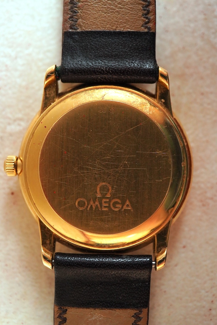 A gentleman's late 1990's 18ct gold Omega Automatic Chronometer wrist watch, with baton numerals and date aperture, case diameter 35mm, on an associated leather stray with plated buckle with Omega insignia, with box and